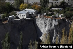 A community hall and houses show signs of damage after flooding from a nearby glacier melt in Hassanabad.