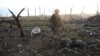 A Ukrainian soldier passes by the body of a dead Russian soldier in Andriyivka in the Donetsk region in September.