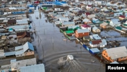 A drone view shows a truck driving along the flooded street in the settlement of Zarechnoye, Orenburg region, Russia, on April 11.