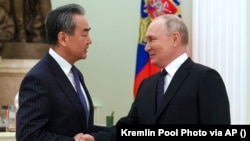 Russian President Vladimir Putin (right) greets Chinese Communist Party foreign policy chief Wang Yi during their meeting at the Kremlin in Moscow on February 22.