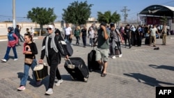 People enter Egypt via the Rafah border crossing in the southern Gaza Strip on November 1. 