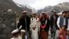 Jaffer Ali Khan, a 31-year-old mason wearing groom's attire, walks with relatives while going to his bride's home during his wedding ceremony in Darkut village in Pakistan on October 13.