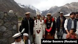 Jaffer Ali Khan, a 31-year-old mason wearing groom's attire, walks with relatives while going to his bride's home during his wedding ceremony in Darkut village in Pakistan on October 13.