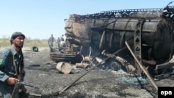 Afghan Police inspect the burned-out oil tankers at the site of the NATO-led air strike in Konduz on September 4.