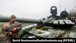 Украинский военный у поврежденного российского танка Т-72БЗ