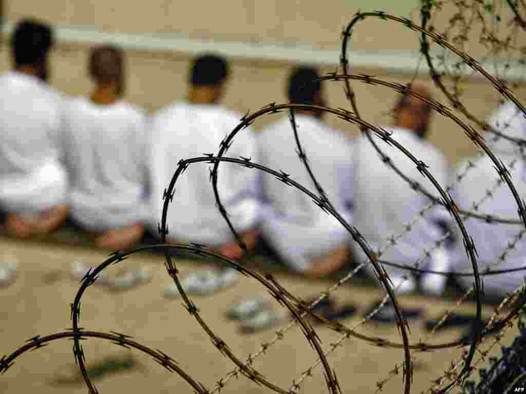 A group of detainees kneels during an early morning Islamic prayer at Guantanamo Bay.