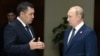 Kyrgyz President Sadyr Japarov (left) speaks with Russian President Vladimir Putin in Astana on October 13.