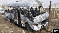 A burnt bus at the scene of a blast blamed by the Syrian authorities on a "terrorist group" near military barracks in Sahnaya on the outskirts of Damascus on January 29.