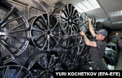 A salesman adjusts wheel rims at an auto parts market in Moscow in June 2022.