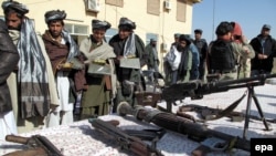 A group of former Taliban militants receive clothes and copies of the Koran as they surrender their weapons during a reconciliation ceremony in Helmand late last year.