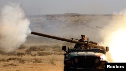 An anti-Qaddafi fighter fires a cannon during a battle with Qaddafi loyalists near Sirte.