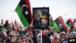 Women wave Libya's post-Qaddafi flag during celebrations in the streets of Tripoli after news of Muammar Qaddafi's capture and death on October 20.