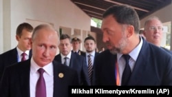 Russian President Vladimir Putin (left) and Russian metals magnate Oleg Deripaska talk at a conference in Danang, Vietnam, in November 2017.