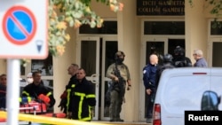 French police, soldiers, and fire fighters work at the site where a teacher was killed and several people injured in a knife attack at a high school in Arras, in northern France