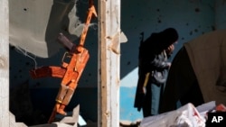 A gun hangs in a house belonging to Islamic State fighters that was destroyed in the ongoing conflict with the Taliban in Kabul on January 5.