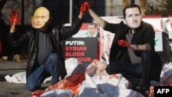 Actors wearing masks of Syrian President Bashar al-Assad and Russian Prime Minister Vladimir Putin perform with body bags during a demonstration outside UN headquarters on January 24. 