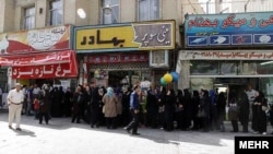 Iranians wait to buy chicken outside a butcher shop in Shiraz in July.