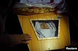 A man touches the coffin of a student who was killed during the attack.