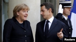 French President Nicolas Sarkozy (right) welcomes German Chancellor Angela Merkel prior to a working lunch at the Elysee Palace in Paris last month.