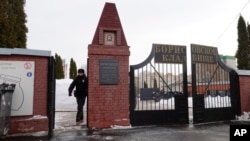 A Russian policeman walks through the gate of the Borisovskoye cemetery on February 28 where the funeral of Russian opposition leader Aleksei Navalny will be held on March 1.