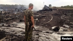 Боевик перед обломками «Боинга». 17 июля 2014 года