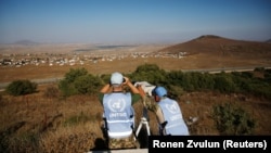 Peacekeeping troops from the unarmed United Nations Truce Supervision Organization look over the border line between Israel and Syria at refugee tents erected on its Syrian side and seen from the Israeli-occupied Golan Heights last month.