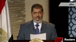 Egyptian President-elect Muhammad Morsi speaks during his first televised address to the nation in Cairo on June 24.