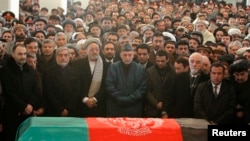 Afghan President Hamid Karzai (center) prays near the flag-draped coffin of Afghan Vice President Marshal Mohammad Qasim Fahim during his burial ceremony at the Presidential Palace in Kabul on March 11.