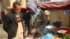 Mohammad Ahmadi (left) speaks to Ghulam, a local vegetable seller, at a campaign rally for Zalmai Rasul in Kabul on March 29.