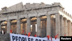 A giant banner protesting Greece's austerity measures hangs near the Parthenon on Acropolis hill in Athens.