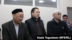 Kenzhebek Abishev (left to right), Almat Zhumaghulov, and Oralbek Omyrov appear in court in Almaty on October 4.