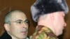 Russia -- Mikhail Khodorkovsky (L) stands inside the bullet-proof glass defendents' cage of a Moscow court, 03Mar2009