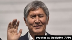 Almazbek Atambaev waves from the defendants' cage during a court hearing in Bishkek in November 2020.