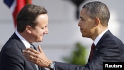 U.S. President Barack Obama (right) greets British Prime Minister David Cameron during an official arrival ceremony for Cameron on the South Lawn of the White House in Washington, D.C., on March 14.