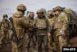 Ukrainian President Volodymyr Zelenskiy (center) visits the troops along the front line in eastern Ukraine on April 8.