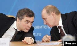 Vladislav Surkov (left) talks with Vladimir Putin at a meeting in 2012.