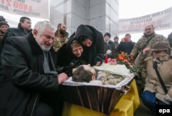 Relatives and friends react during the funeral ceremony in Kyiv for Ukrainian soldier Leonid Dergach, who was killed in renewed fighting near Avdiyivka in eastern Ukraine in early February.