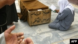 Iraqis pray at the coffin of a victim killed in a car bombing in Baghdad in April 2009.