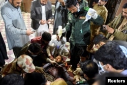 A passenger who was rescued from the train receives medical aid at the Mach Railway Station in Mach, Balochistan, Pakistan, on March 11.