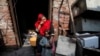 Anzila Semeul cries while sitting with her daughter in front of their home after it was lit on fire by a mob two days earlier, in Badami Bagh, Lahore, in March 2013.