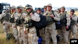 Georgian soldiers carry their gears upon their arrival from Iraq at Tbilisi airport in August 2008.