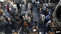 Pakistanis gather among the wreckage a day after two powerful bomb blasts at a market in Lahore.