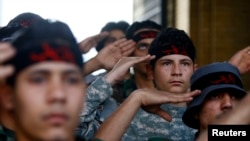 Iraqi Shi'ite fighters salute to the shrine of Sayeda Zeinab, a granddaughter of the Prophet Mohammad, in Damascus on May 25.