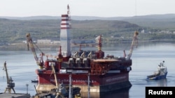 A floating oil platform is tugged from the harbor in Russia's northern port of Murmansk.