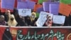 Women holding banners and placards take part in a march on International Women's Day in Lahore on March 8, 2021.