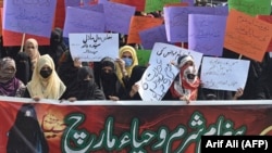 Women holding banners and placards take part in a march on International Women's Day in Lahore on March 8, 2021.