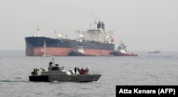 An Iranian military speedboat patrols the waters as a tanker prepares to dock at an oil facility on Kharg Island in the Persian Gulf. (file photo)