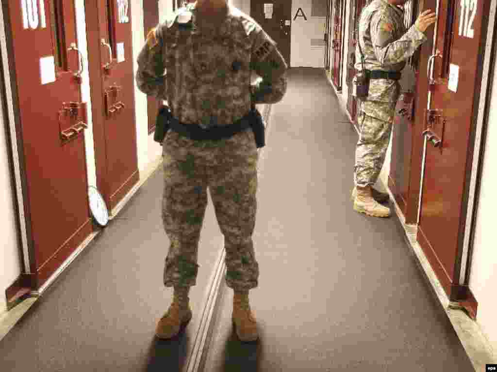 A U.S. soldier stands guard as another does a cell check in Camp Delta at Guantanamo Bay in October 2007.