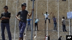  Libyan men stand during a protest after Friday prayers in Green Square, downtown Tripoli, July 8, 2011 