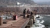 A Chinese engineer supervises workers building a bridge over a river in Ghari Dupatta, Pakistan. 